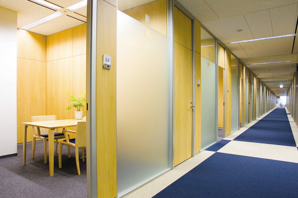 企業ブランドカラーである紺碧のカーペットが敷かれたカウンセリングフロア