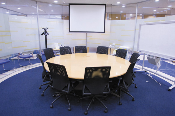 ガラス張りの解放感ある、円卓を配置したミーティングルーム